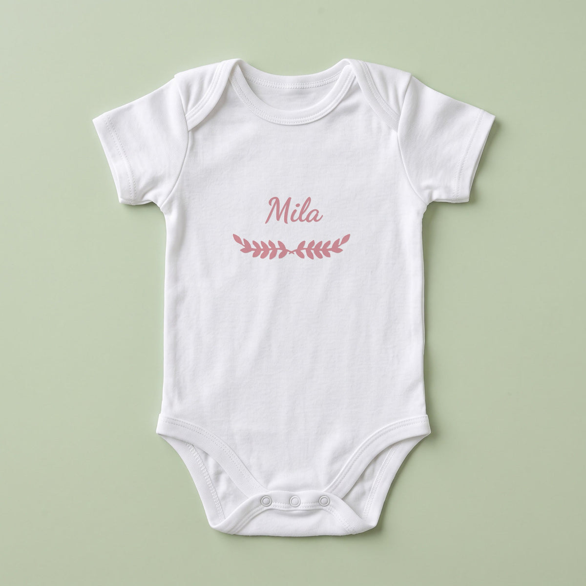 Body bébé blanc personnalisé Mila — prénom « Mila » marqué sur la poitrine, ornement Feuillage