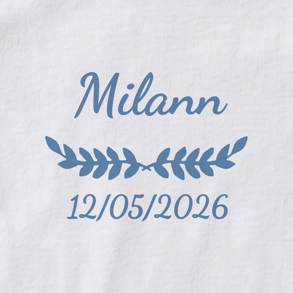 Body bébé personnalisé Milann — gros plan du marquage « Milann », ornement Feuillage et date de naissance « 12/05/2026 »