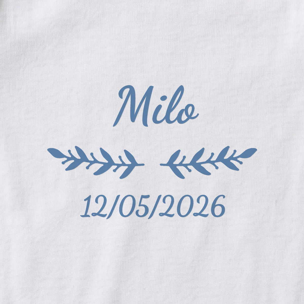 Body bébé personnalisé Milo — gros plan du marquage « Milo », ornement Rameaux et date de naissance « 12/05/2026 »