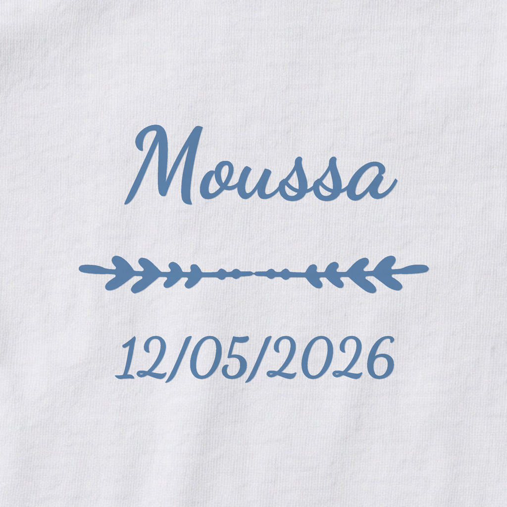 Body bébé personnalisé Moussa — gros plan du marquage « Moussa », ornement Flèche et date de naissance « 12/05/2026 »