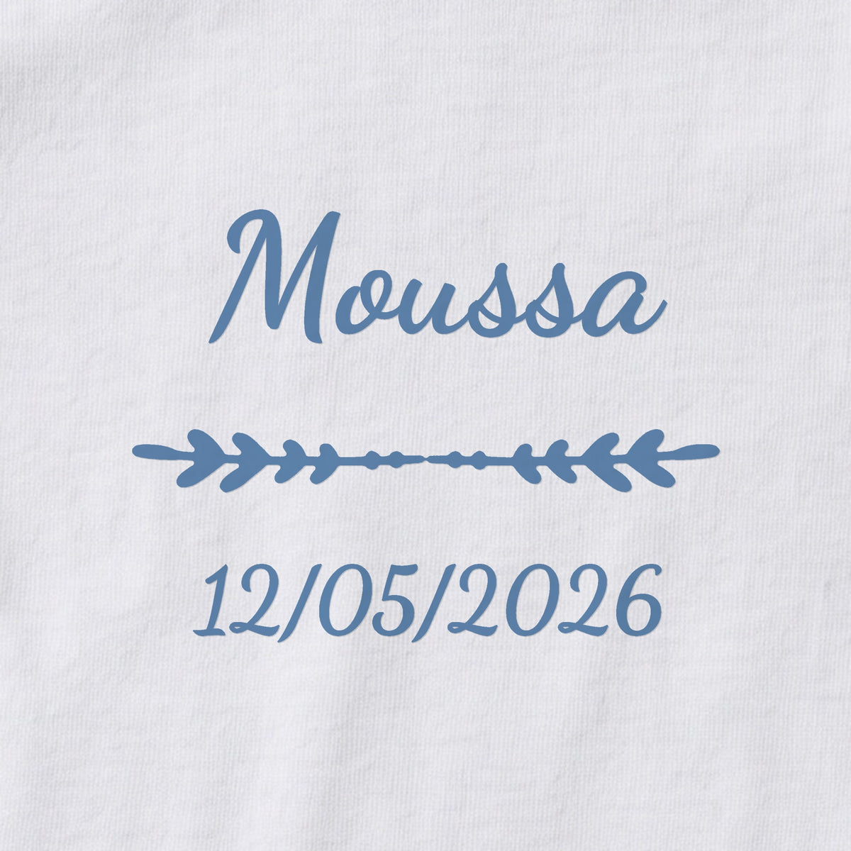Body bébé personnalisé Moussa — gros plan du marquage « Moussa », ornement Flèche et date de naissance « 12/05/2026 »