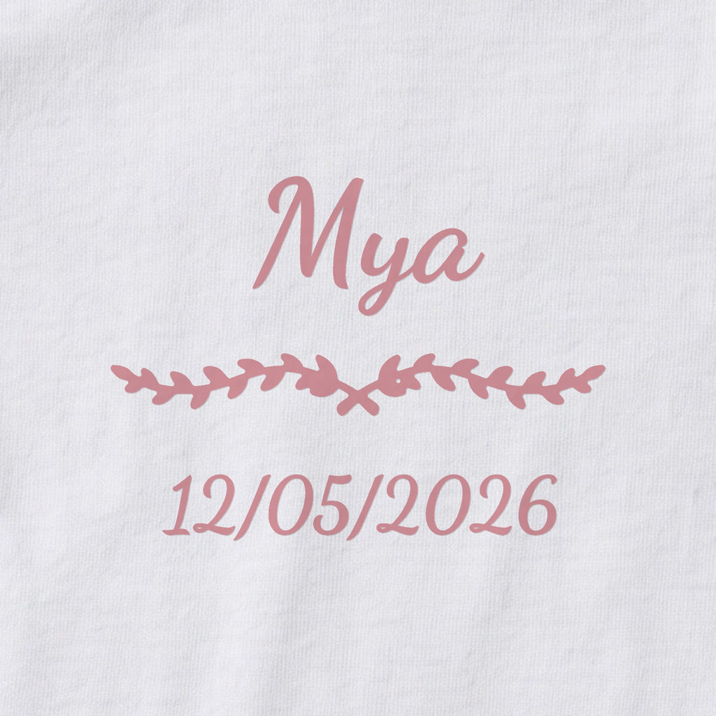Body bébé personnalisé Mya — gros plan du marquage « Mya », ornement Liane et date de naissance « 12/05/2026 »