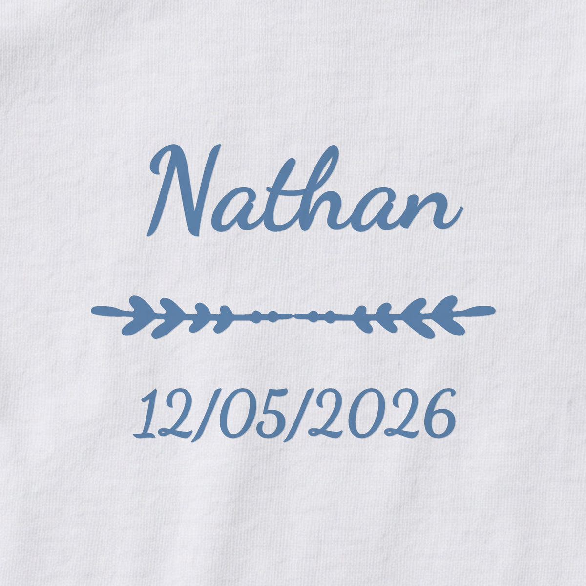 Body bébé personnalisé Nathan — gros plan du marquage « Nathan », ornement Flèche et date de naissance « 12/05/2026 »