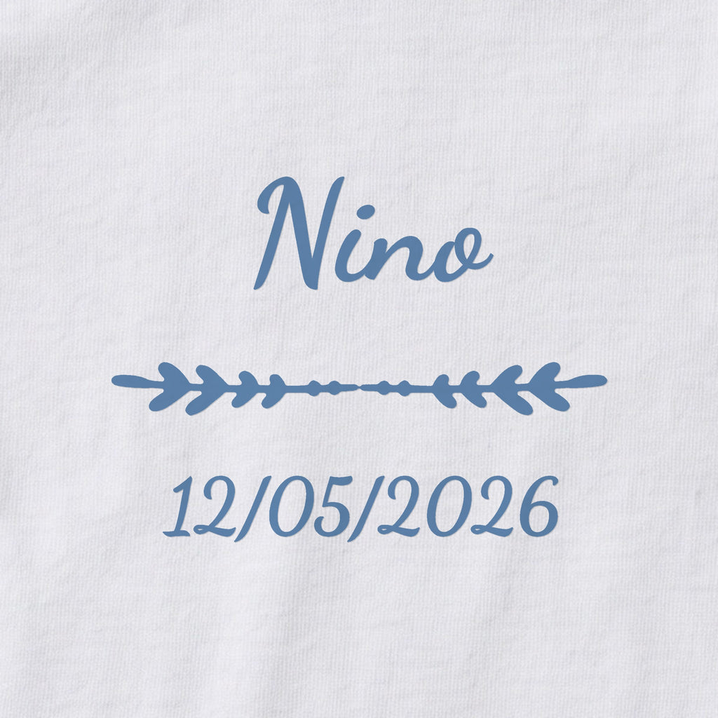 Body bébé personnalisé Nino — gros plan du marquage « Nino », ornement Flèche et date de naissance « 12/05/2026 »