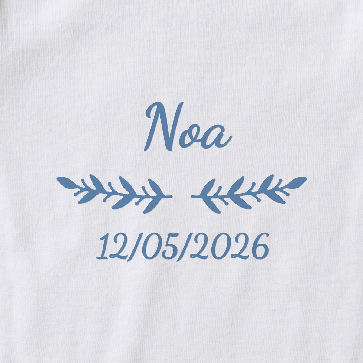 Body bébé personnalisé Noa — gros plan du marquage « Noa », ornement Rameaux et date de naissance « 12/05/2026 »