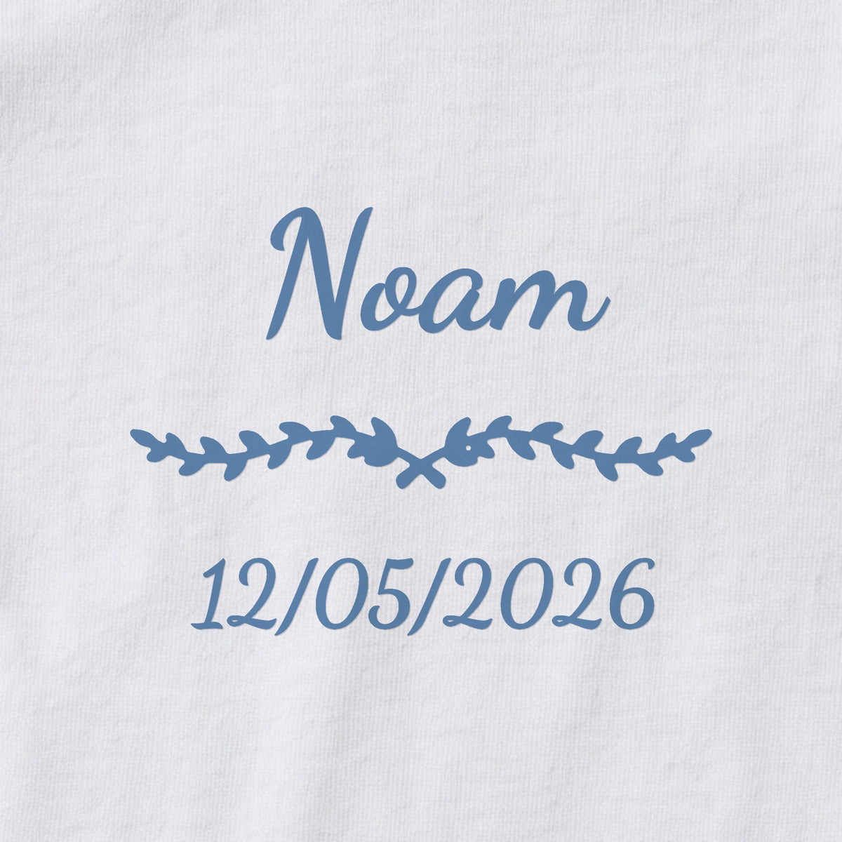 Body bébé personnalisé Noam — gros plan du marquage « Noam », ornement Liane et date de naissance « 12/05/2026 »