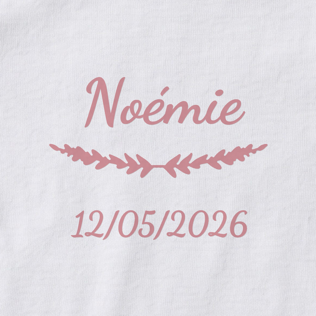 Body bébé personnalisé Noémie — gros plan du marquage « Noémie », ornement Brindilles et date de naissance « 12/05/2026 »