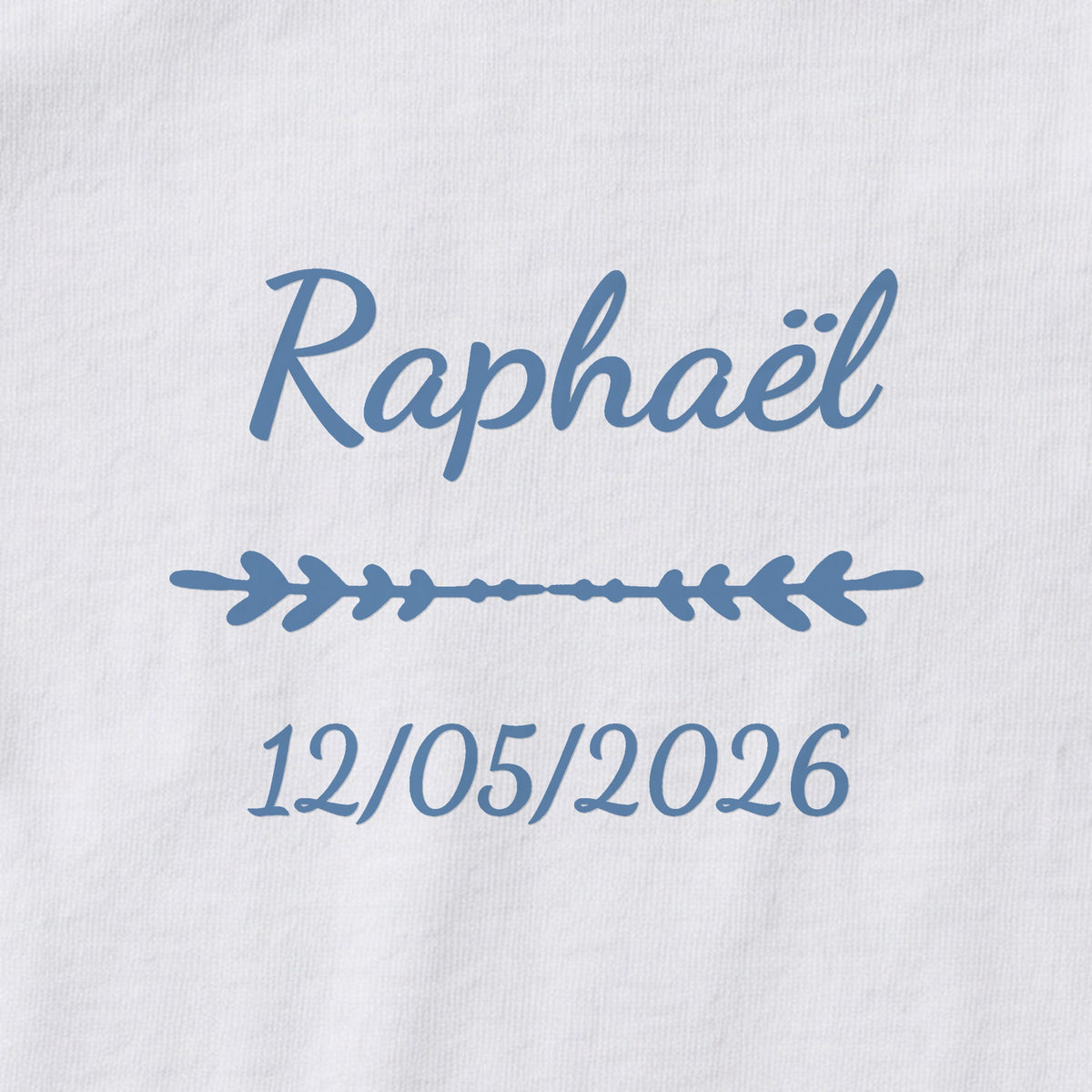 Body bébé personnalisé Raphaël — gros plan du marquage « Raphaël », ornement Flèche et date de naissance « 12/05/2026 »