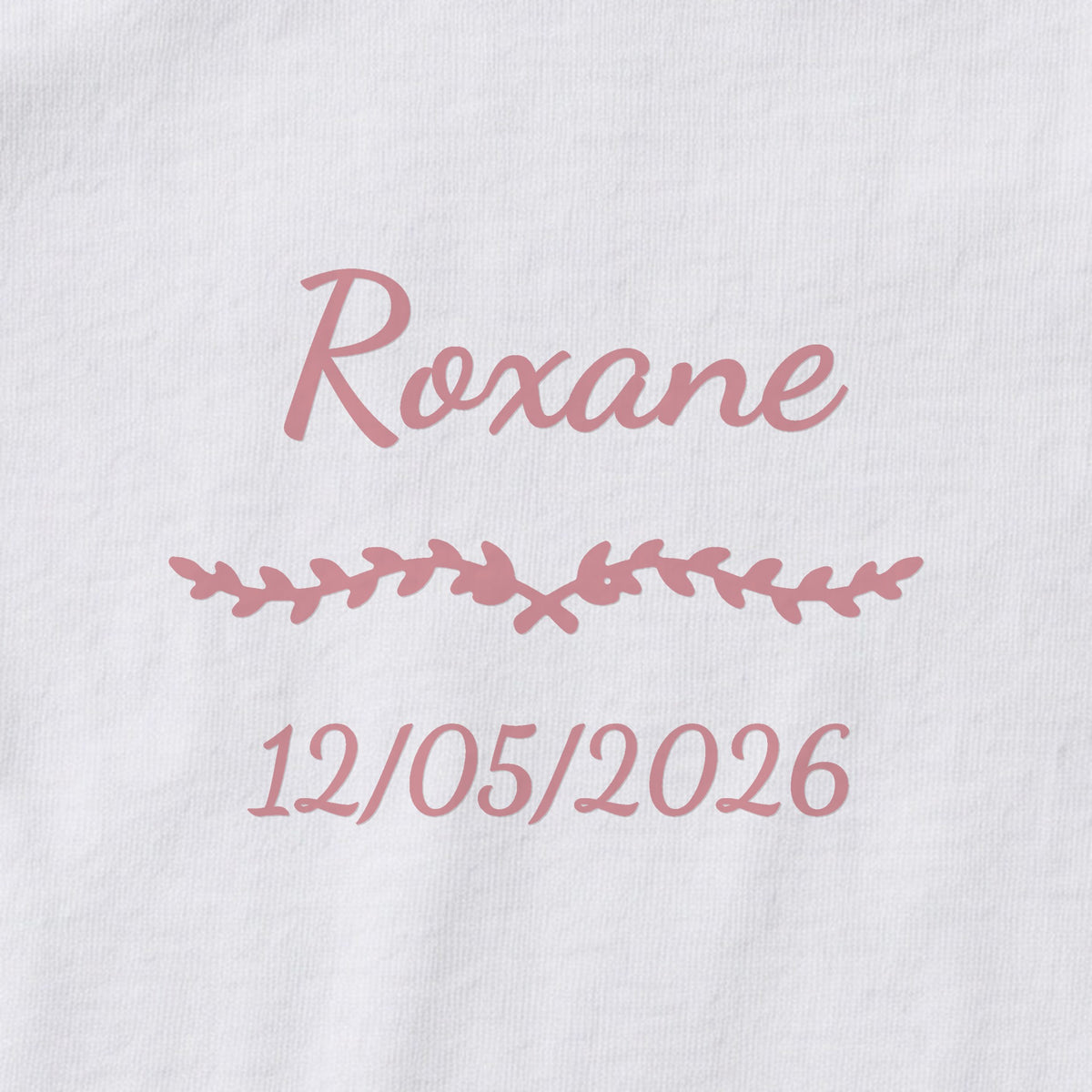 Body bébé personnalisé Roxane — gros plan du marquage « Roxane », ornement Liane et date de naissance « 12/05/2026 »