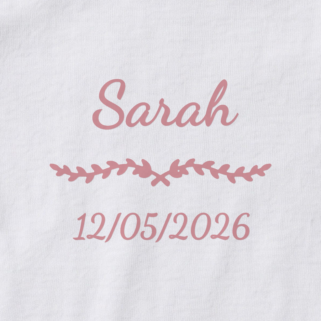 Body bébé personnalisé Sarah — gros plan du marquage « Sarah », ornement Liane et date de naissance « 12/05/2026 »