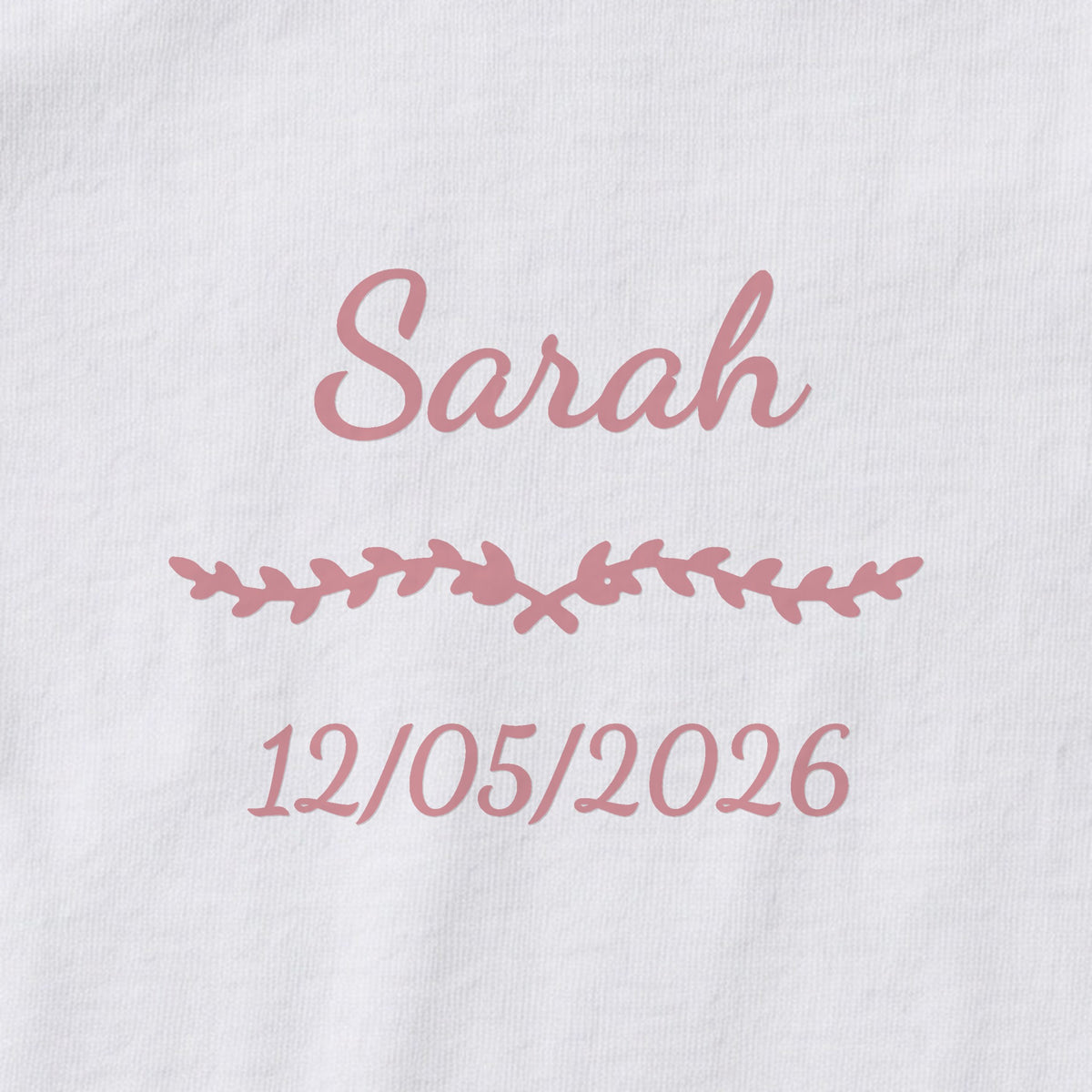 Body bébé personnalisé Sarah — gros plan du marquage « Sarah », ornement Liane et date de naissance « 12/05/2026 »