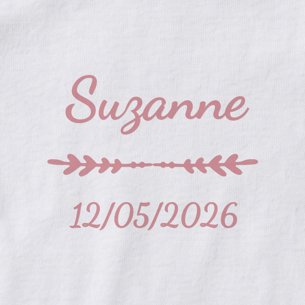 Body bébé personnalisé Suzanne — gros plan du marquage « Suzanne », ornement Flèche et date de naissance « 12/05/2026 »