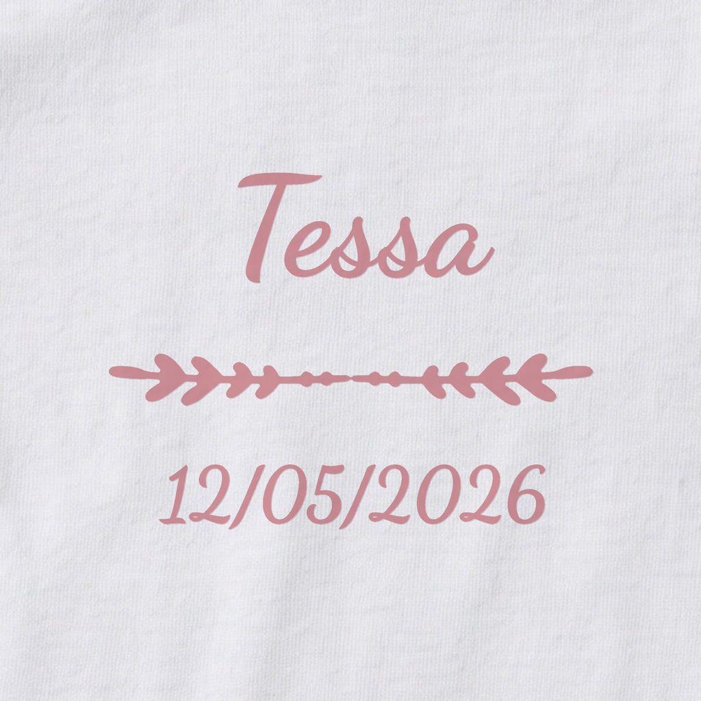 Body bébé personnalisé Tessa — gros plan du marquage « Tessa », ornement Flèche et date de naissance « 12/05/2026 »