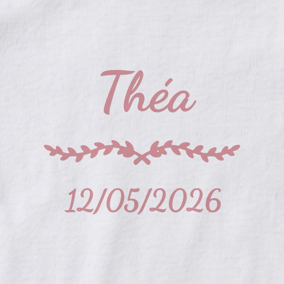 Body bébé personnalisé Théa — gros plan du marquage « Théa », ornement Liane et date de naissance « 12/05/2026 »