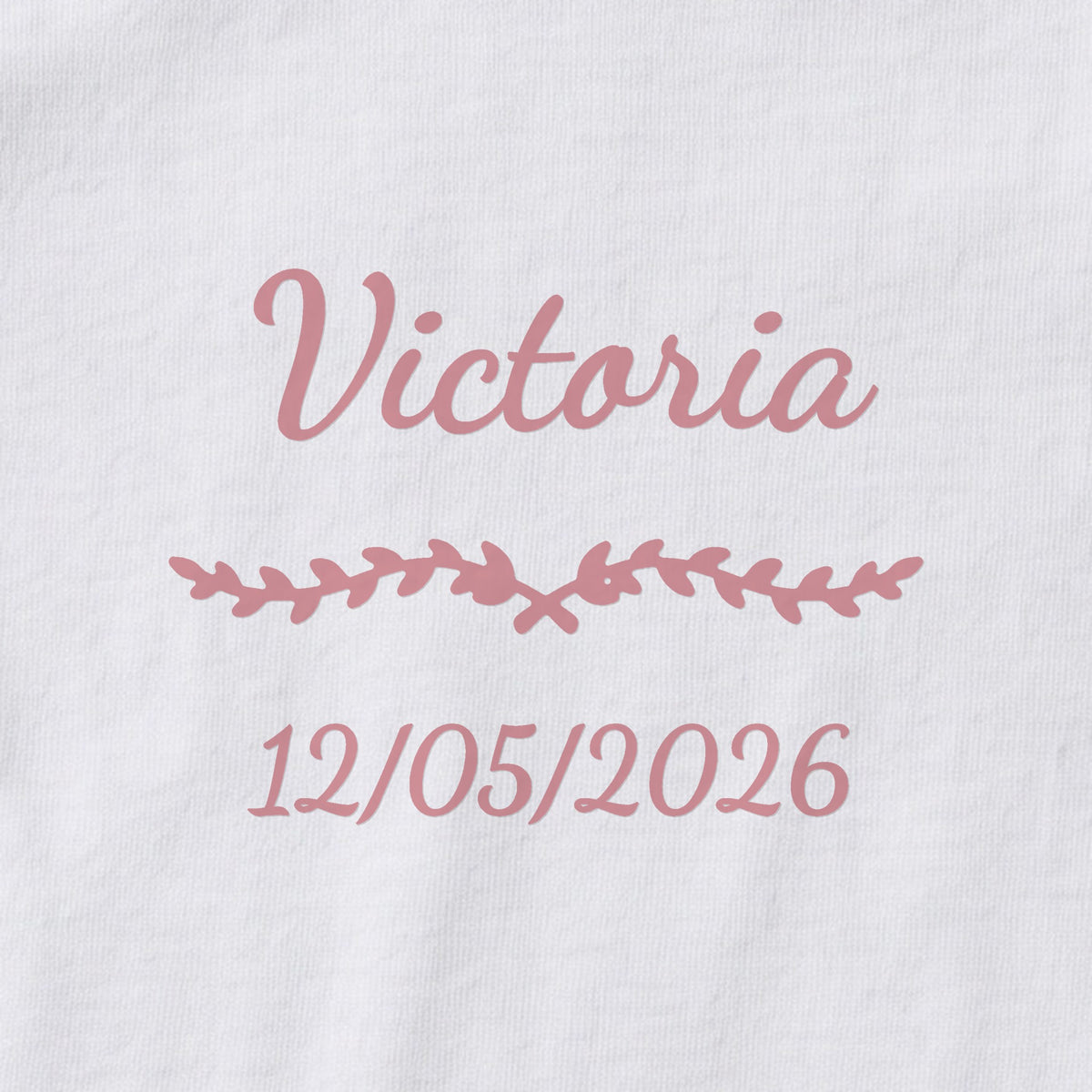 Body bébé personnalisé Victoria — gros plan du marquage « Victoria », ornement Liane et date de naissance « 12/05/2026 »