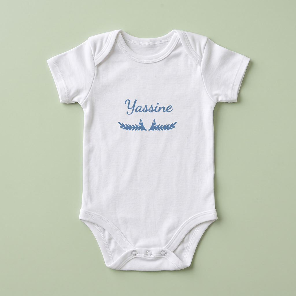 Body bébé blanc personnalisé Yassine — prénom « Yassine » marqué sur la poitrine, ornement Bouquet