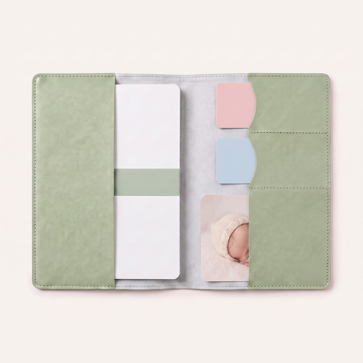 Protège carnet de santé bébé personnalisé – Zèbre — ouvert avec le carnet et 3 cartes glissées dans les emplacements (visuel de mise en scène, coloris Vert sauge)