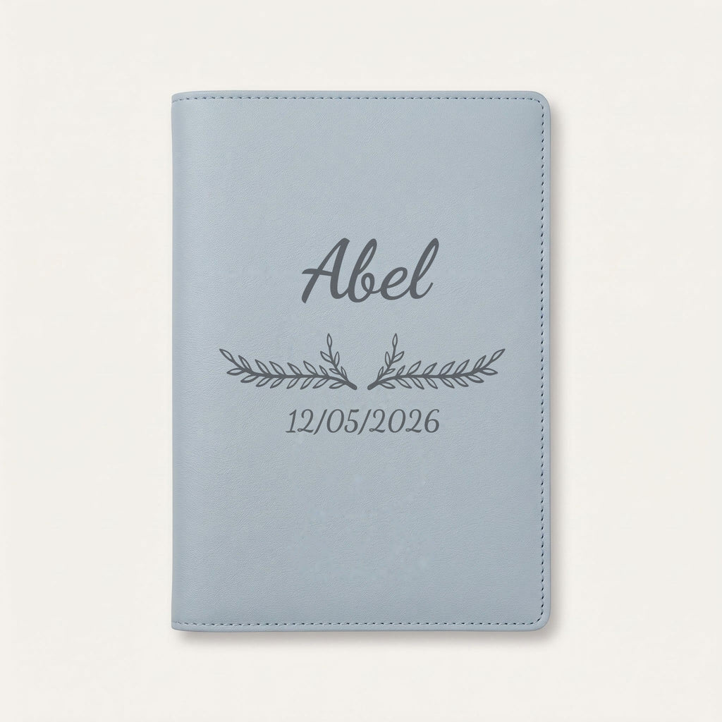 Protège carnet de santé personnalisé Abel — Bleu nuage — prénom « Abel », ornement Bouquet et date de naissance « 12/05/2026 » gravés