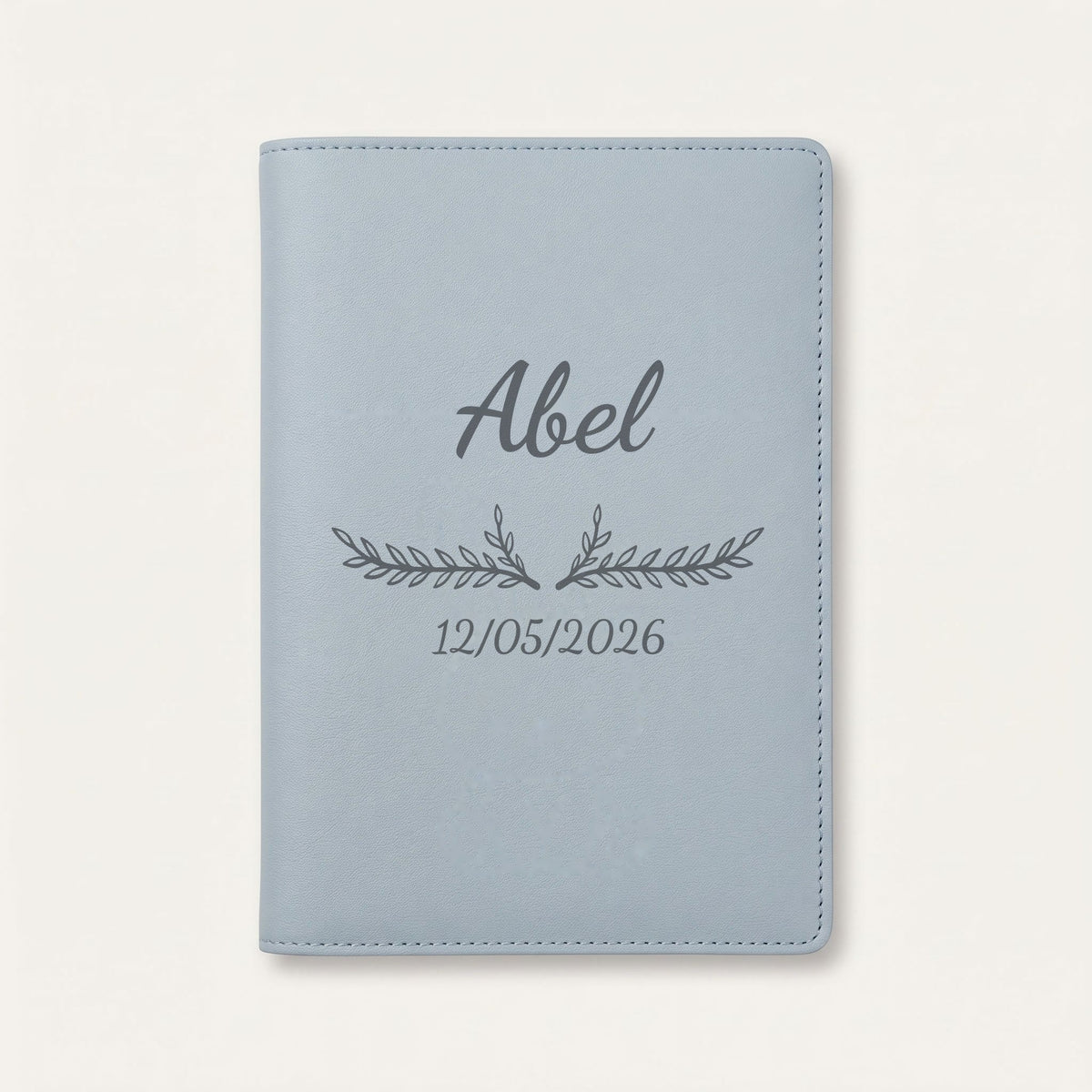 Protège carnet de santé personnalisé Abel — Bleu nuage — prénom « Abel », ornement Bouquet et date de naissance « 12/05/2026 » gravés