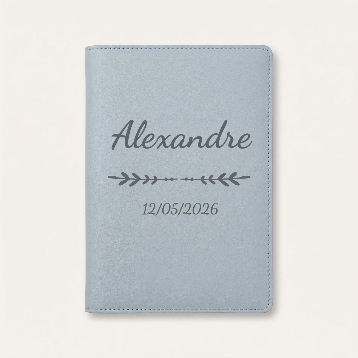 Protège carnet de santé personnalisé Alexandre — Bleu nuage — prénom « Alexandre », ornement Flèche et date de naissance « 12/05/2026 » gravés