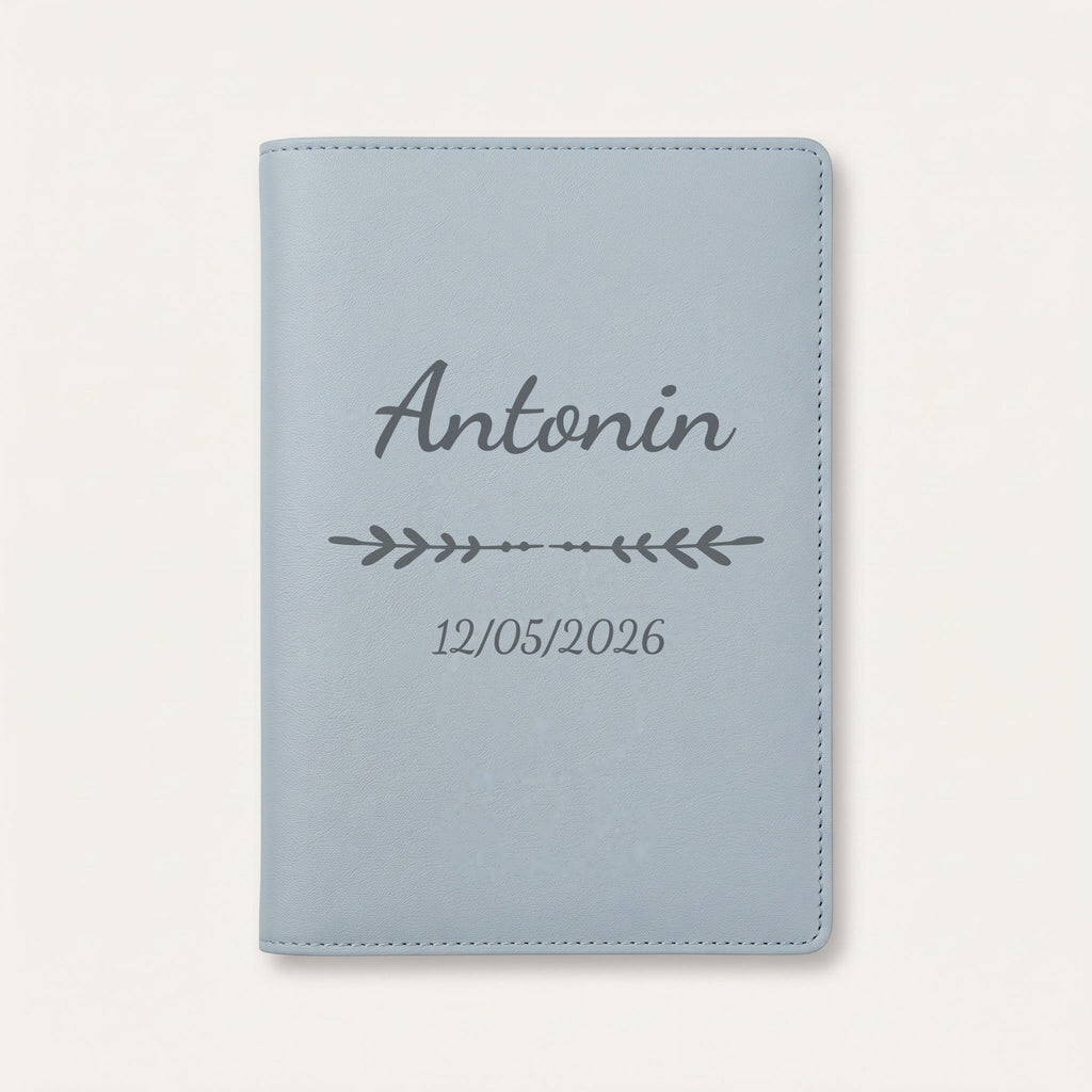 Protège carnet de santé personnalisé Antonin — Bleu nuage — prénom « Antonin », ornement Flèche et date de naissance « 12/05/2026 » gravés