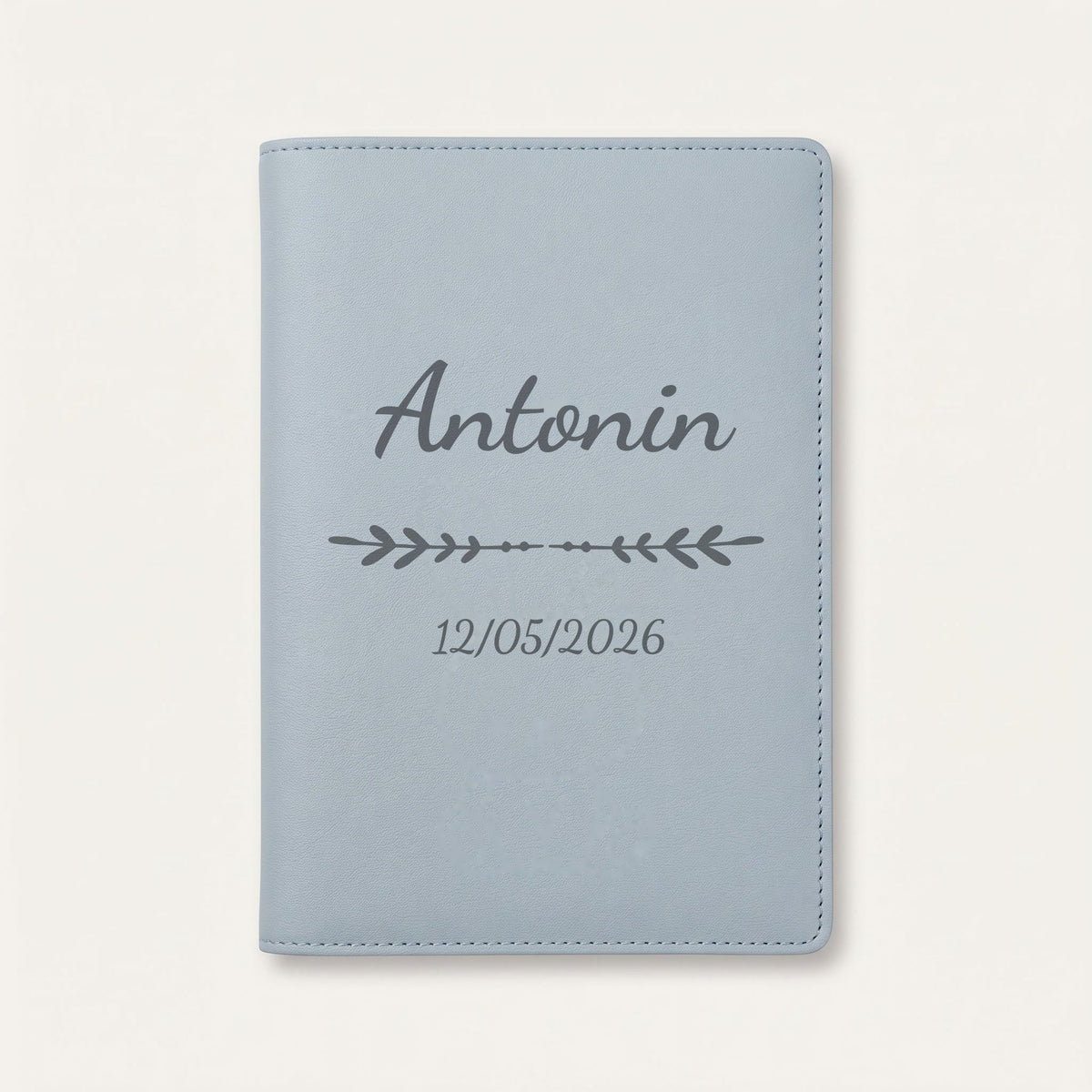 Protège carnet de santé personnalisé Antonin — Bleu nuage — prénom « Antonin », ornement Flèche et date de naissance « 12/05/2026 » gravés