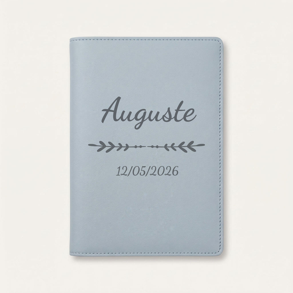 Protège carnet de santé personnalisé Auguste — Bleu nuage — prénom « Auguste », ornement Flèche et date de naissance « 12/05/2026 » gravés