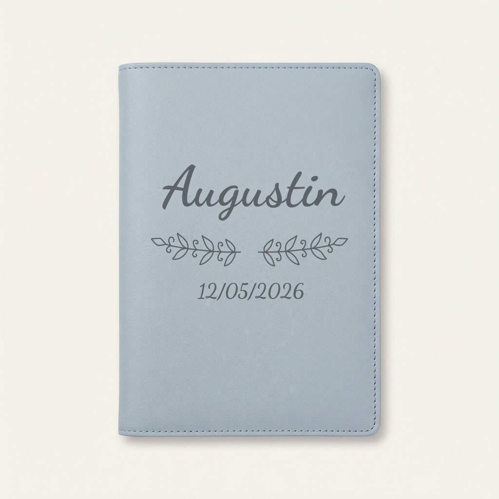 Protège carnet de santé personnalisé Augustin — Bleu nuage — prénom « Augustin », ornement Volutes et date de naissance « 12/05/2026 » gravés