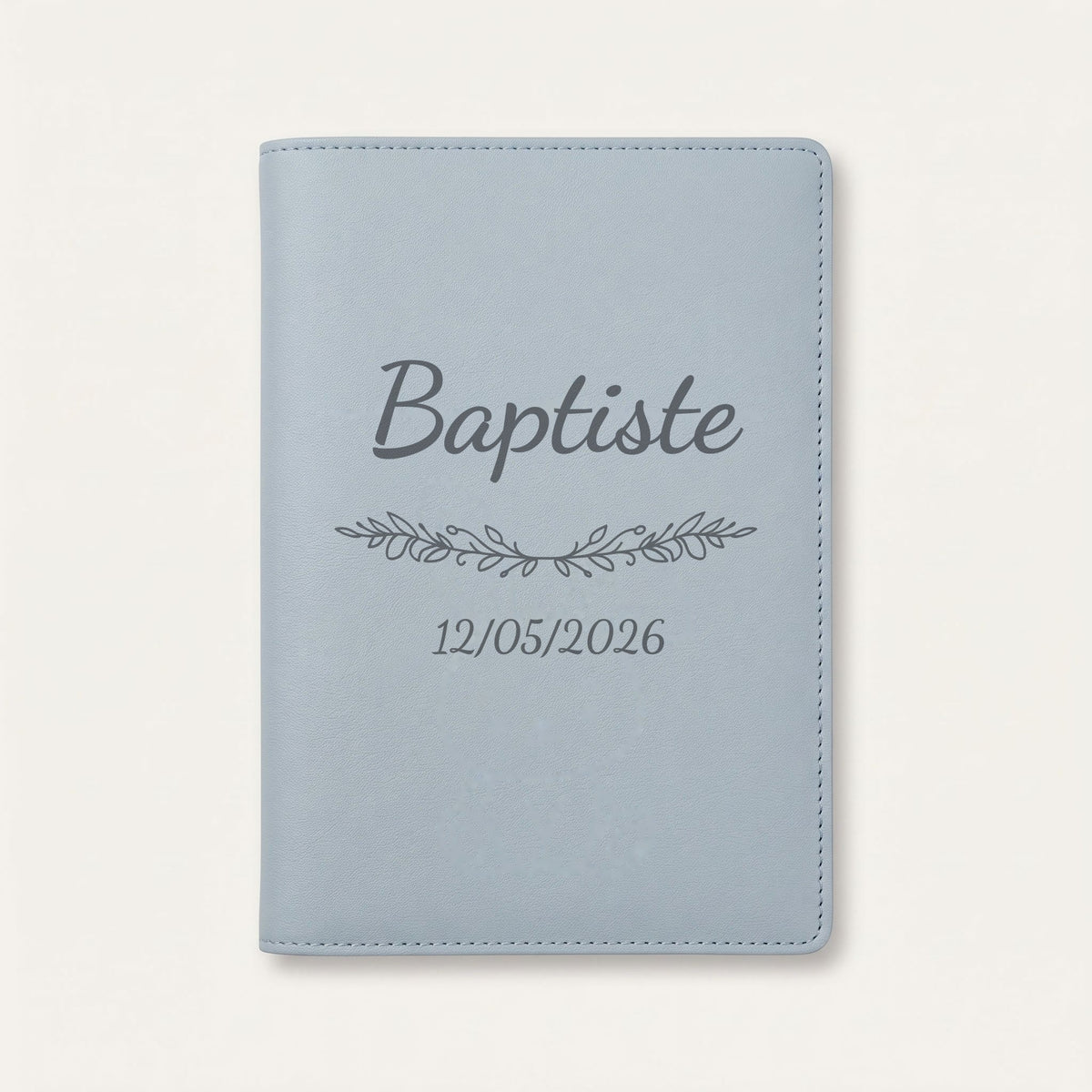 Protège carnet de santé personnalisé Baptiste — Bleu nuage — prénom « Baptiste », ornement Guirlande et date de naissance « 12/05/2026 » gravés