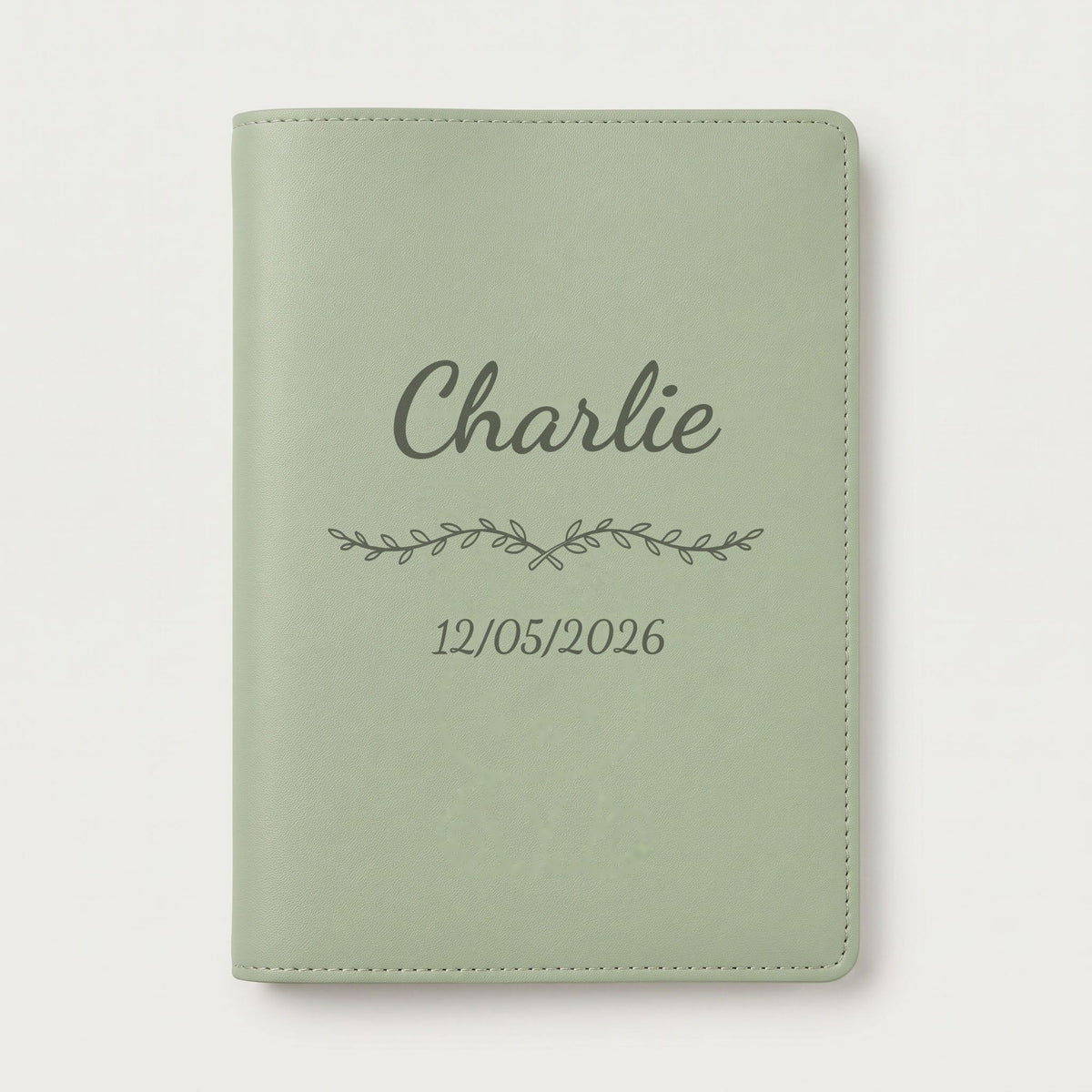 Protège carnet de santé personnalisé Charlie — Vert sauge — prénom « Charlie », ornement Liane et date de naissance « 12/05/2026 » gravés