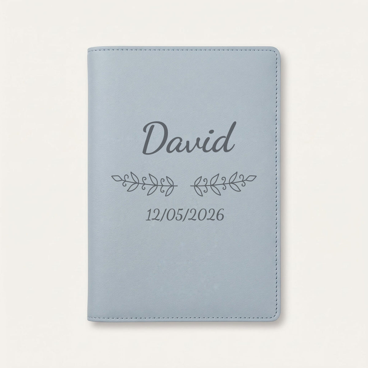 Protège carnet de santé personnalisé David — Bleu nuage — prénom « David », ornement Volutes et date de naissance « 12/05/2026 » gravés