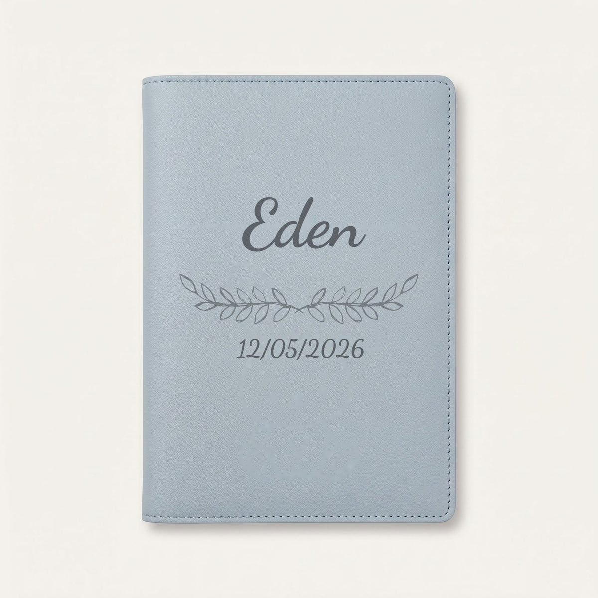 Protège carnet de santé personnalisé Eden — Bleu nuage — prénom « Eden », ornement Feuillage et date de naissance « 12/05/2026 » gravés