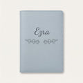 Protège carnet de santé personnalisé Ezra — Bleu nuage — prénom « Ezra » gravé, ornement Volutes