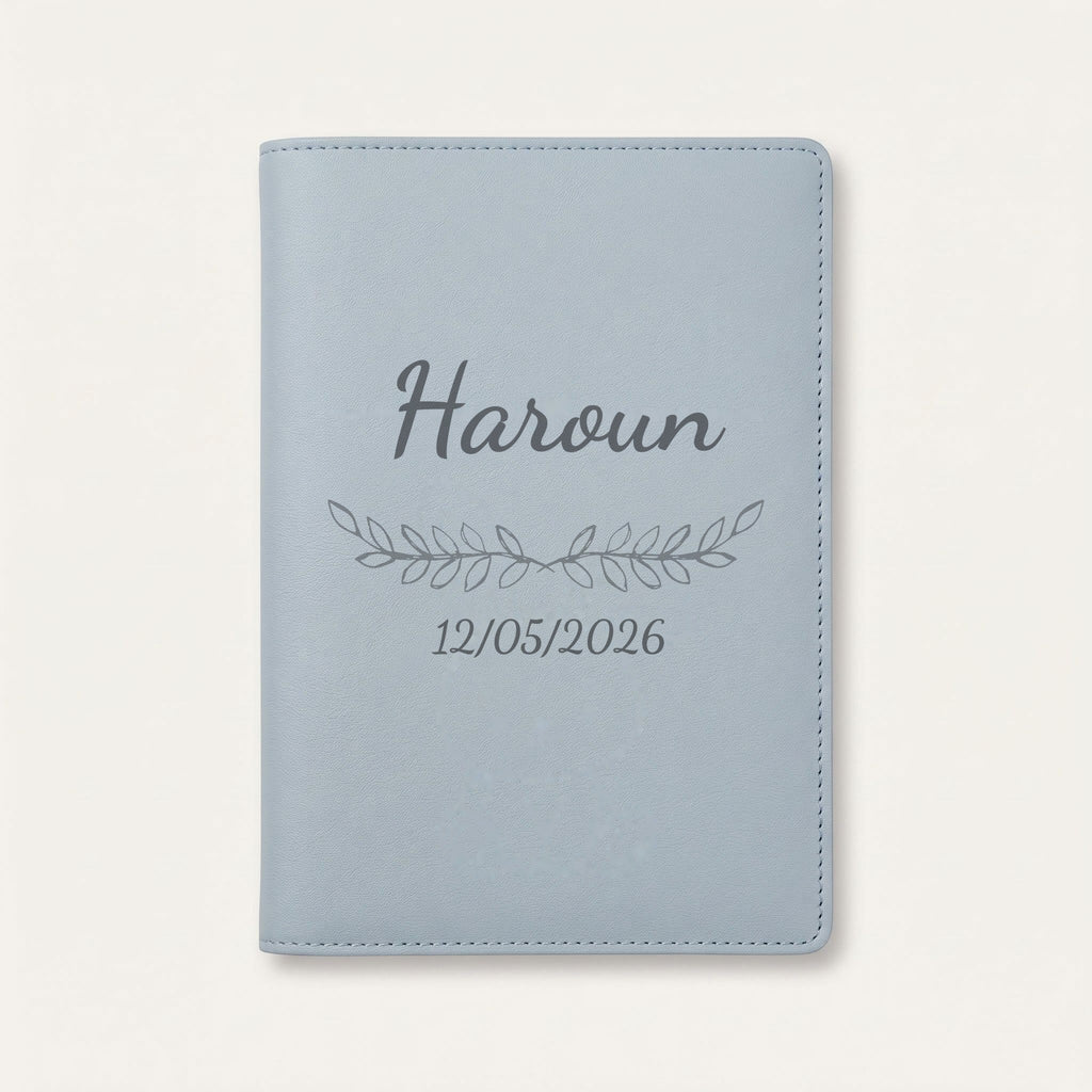 Protège carnet de santé personnalisé Haroun — Bleu nuage — prénom « Haroun », ornement Feuillage et date de naissance « 12/05/2026 » gravés