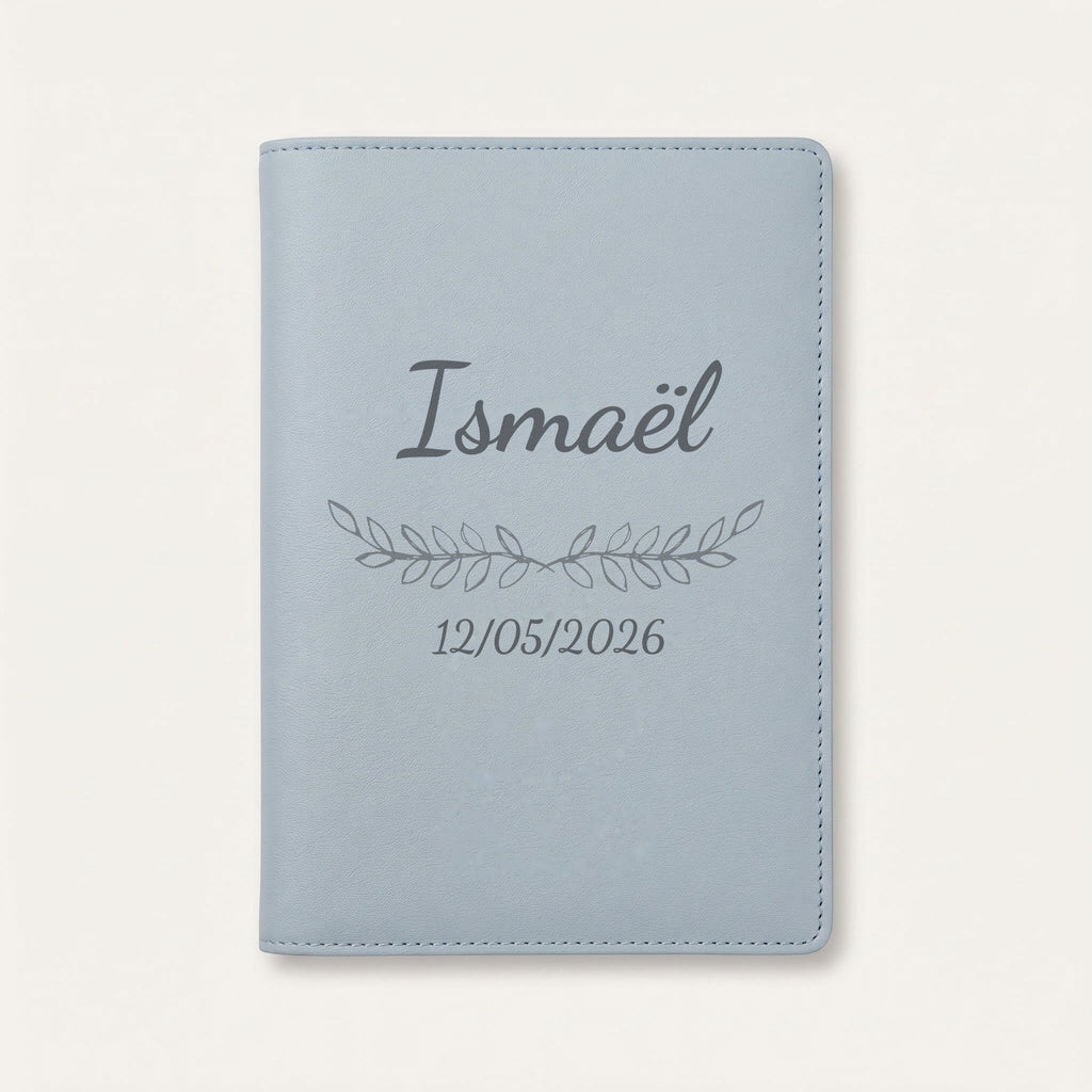 Protège carnet de santé personnalisé Ismaël — Bleu nuage — prénom « Ismaël », ornement Feuillage et date de naissance « 12/05/2026 » gravés