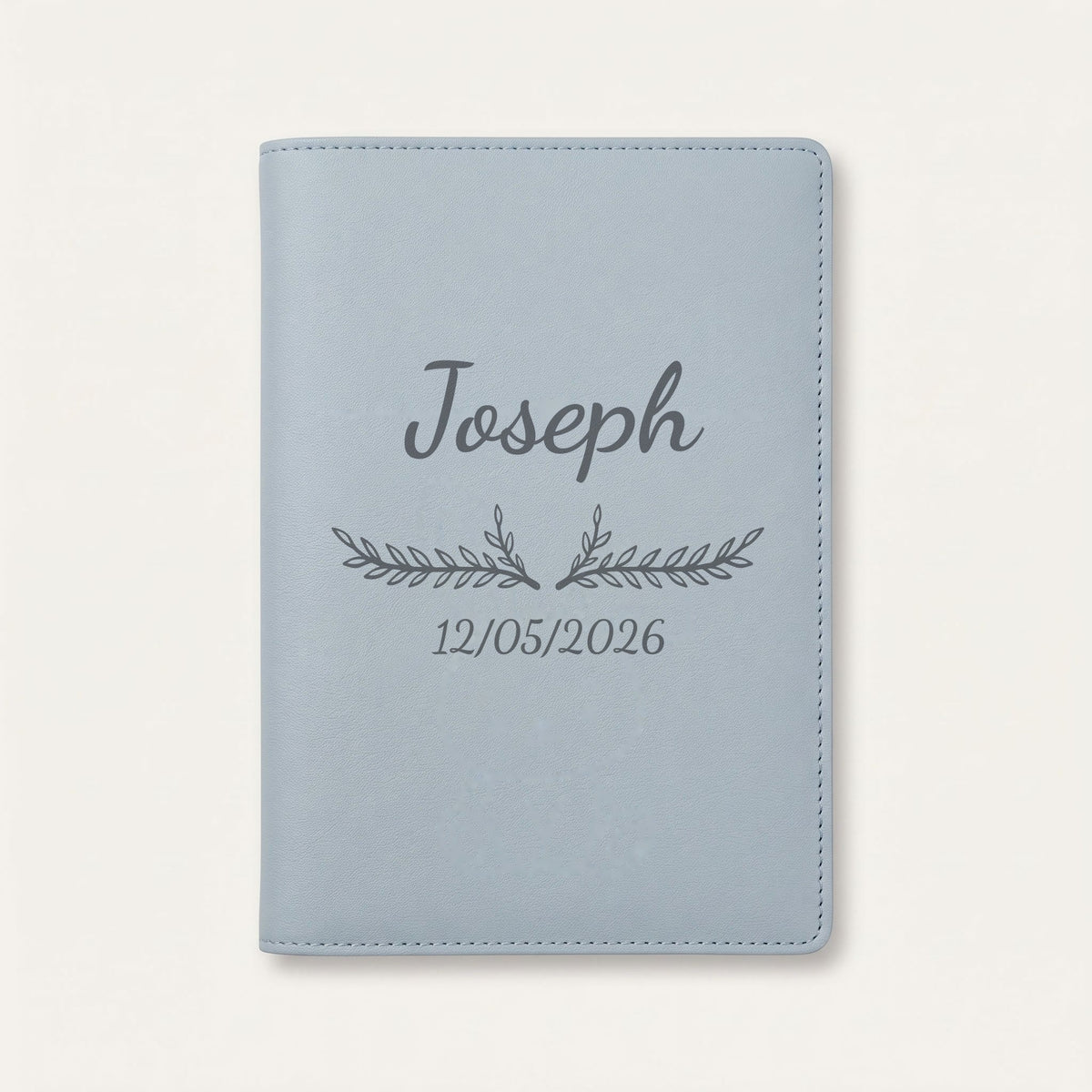 Protège carnet de santé personnalisé Joseph — Bleu nuage — prénom « Joseph », ornement Bouquet et date de naissance « 12/05/2026 » gravés