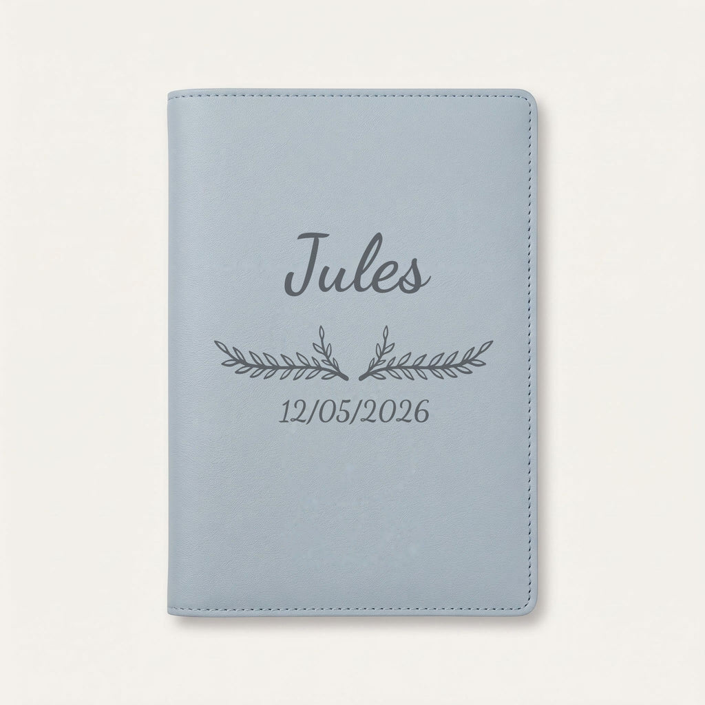Protège carnet de santé personnalisé Jules — Bleu nuage — prénom « Jules », ornement Bouquet et date de naissance « 12/05/2026 » gravés