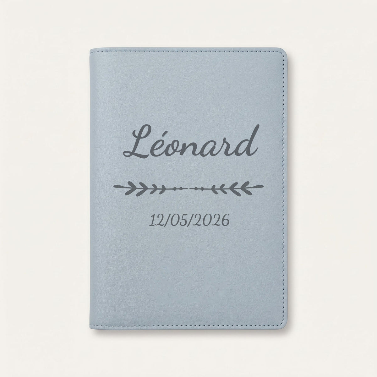 Protège carnet de santé personnalisé Léonard — Bleu nuage — prénom « Léonard », ornement Flèche et date de naissance « 12/05/2026 » gravés