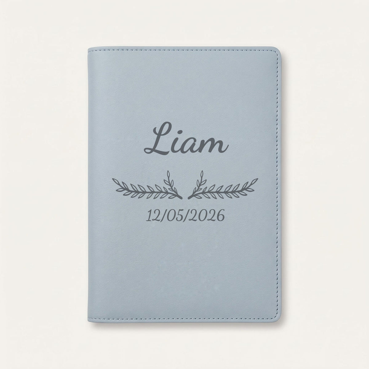 Protège carnet de santé personnalisé Liam — Bleu nuage — prénom « Liam », ornement Bouquet et date de naissance « 12/05/2026 » gravés