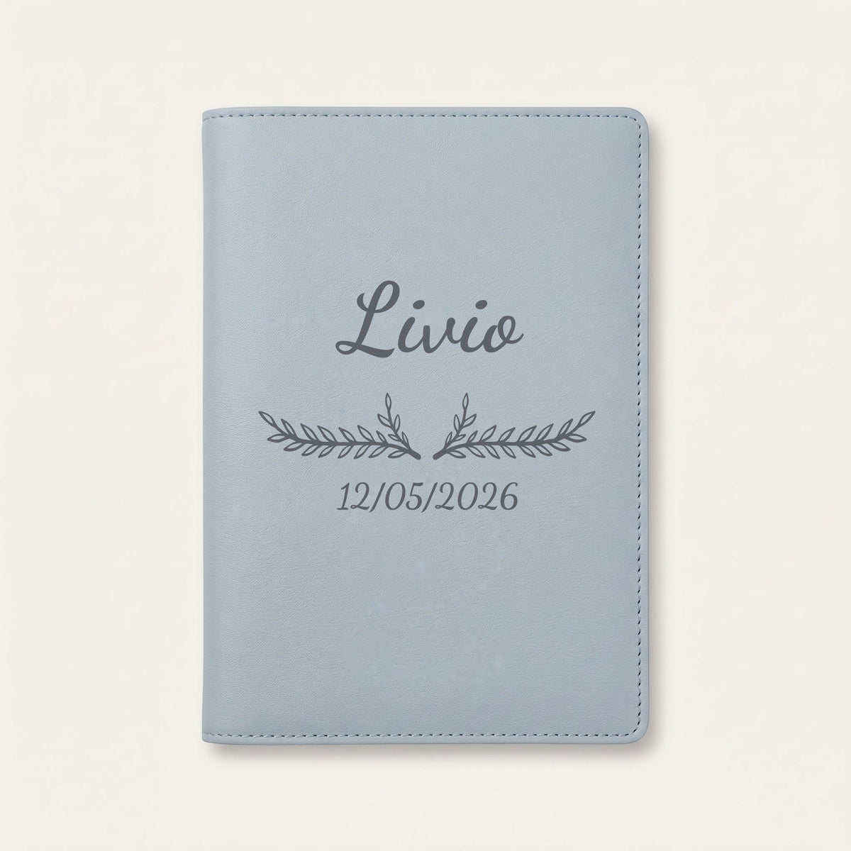 Protège carnet de santé personnalisé Livio — Bleu nuage — prénom « Livio », ornement Bouquet et date de naissance « 12/05/2026 » gravés
