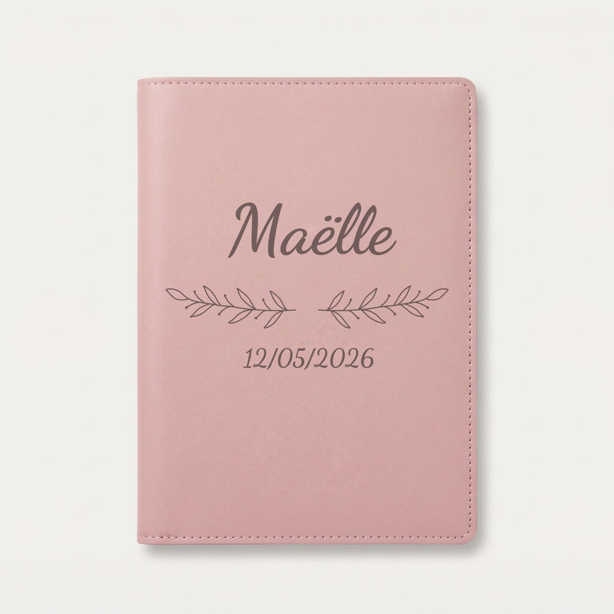 Protège carnet de santé personnalisé Maëlle — Rose dragée — prénom « Maëlle », ornement Rameaux et date de naissance « 12/05/2026 » gravés