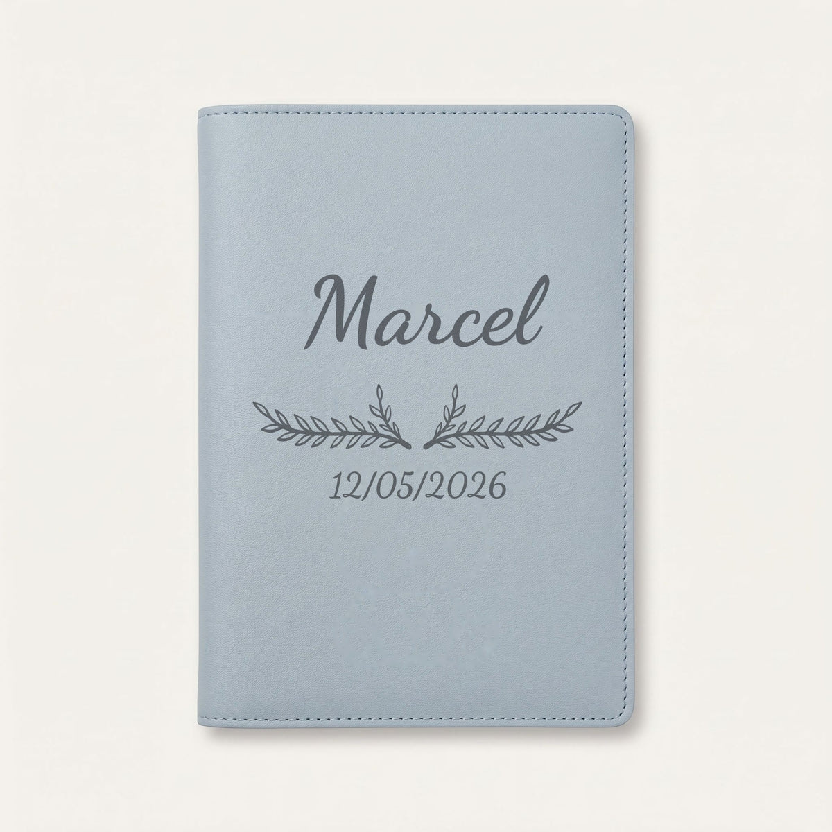 Protège carnet de santé personnalisé Marcel — Bleu nuage — prénom « Marcel », ornement Bouquet et date de naissance « 12/05/2026 » gravés