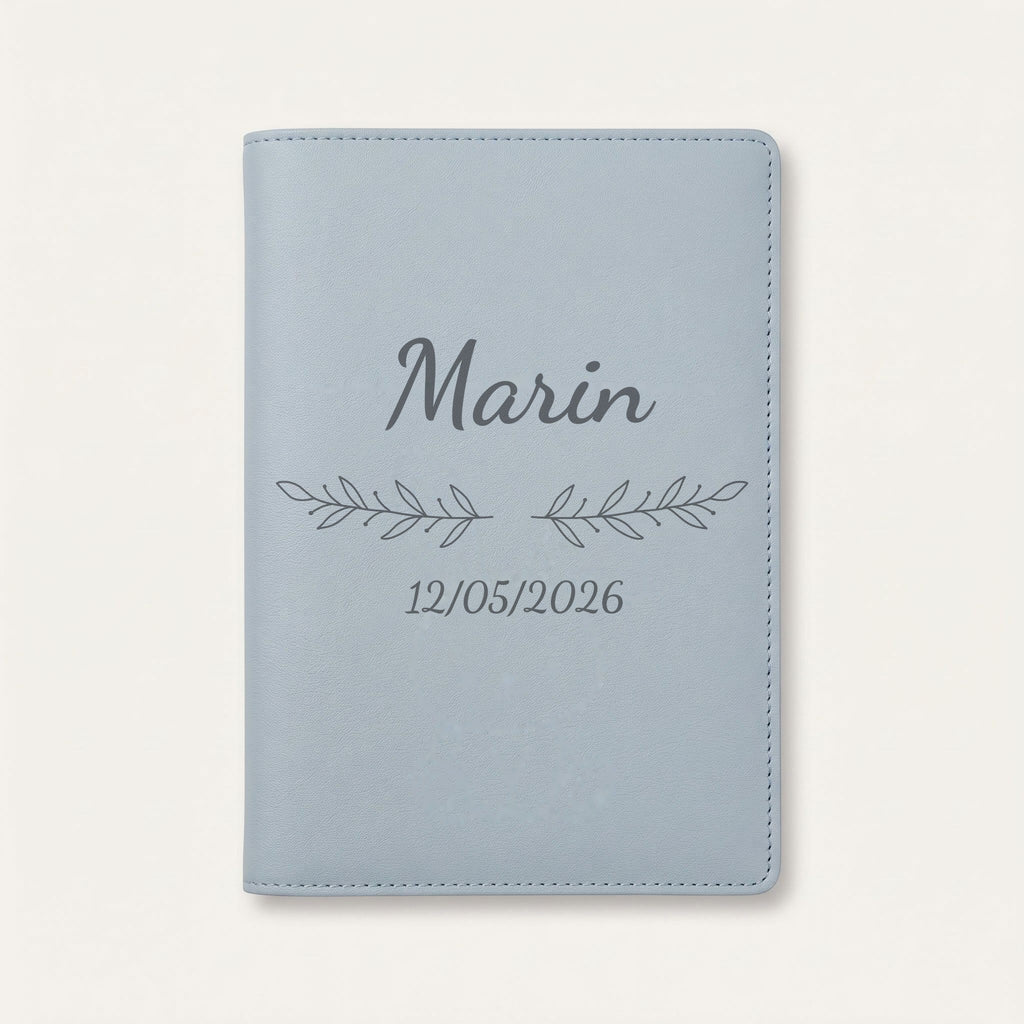 Protège carnet de santé personnalisé Marin — Bleu nuage — prénom « Marin », ornement Rameaux et date de naissance « 12/05/2026 » gravés