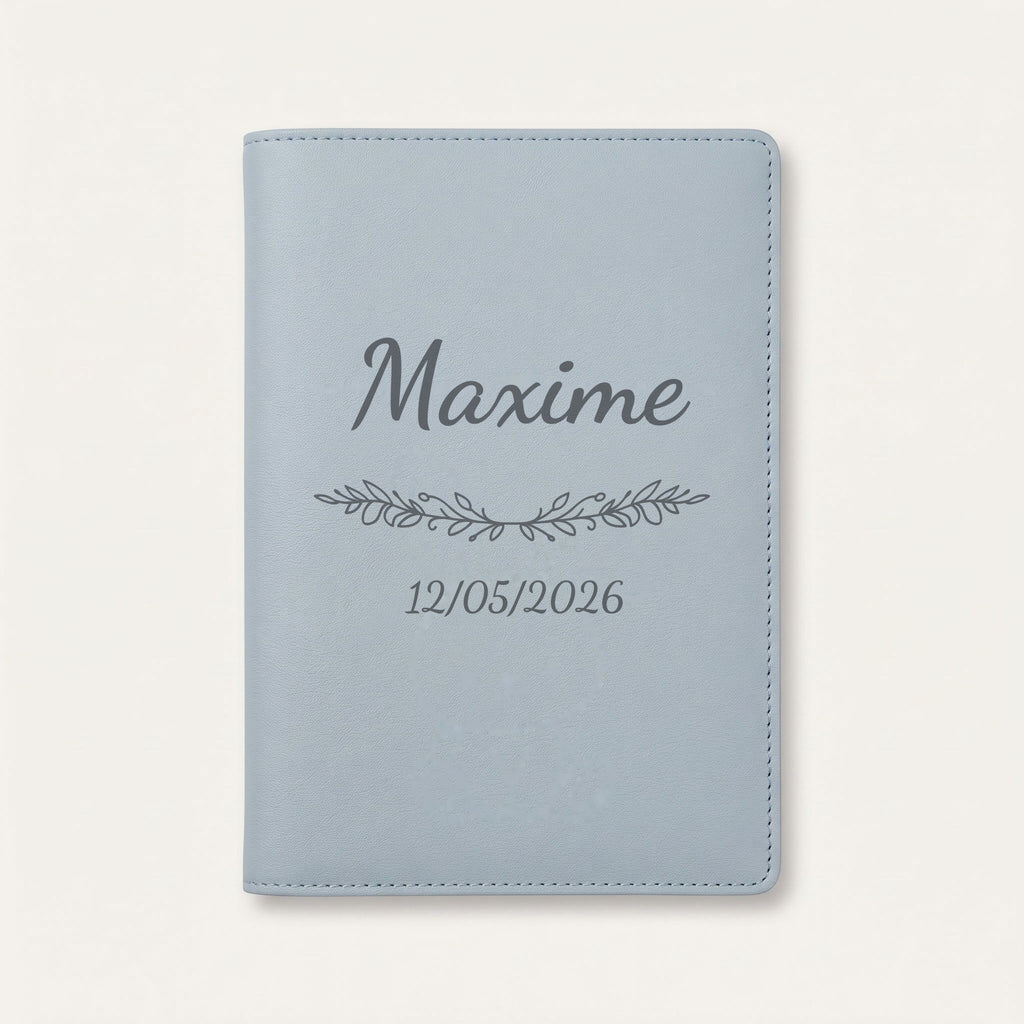 Protège carnet de santé personnalisé Maxime — Bleu nuage — prénom « Maxime », ornement Guirlande et date de naissance « 12/05/2026 » gravés