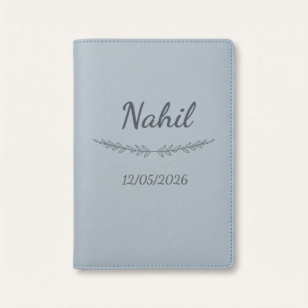 Protège carnet de santé personnalisé Nahil — Bleu nuage — prénom « Nahil », ornement Brindilles et date de naissance « 12/05/2026 » gravés