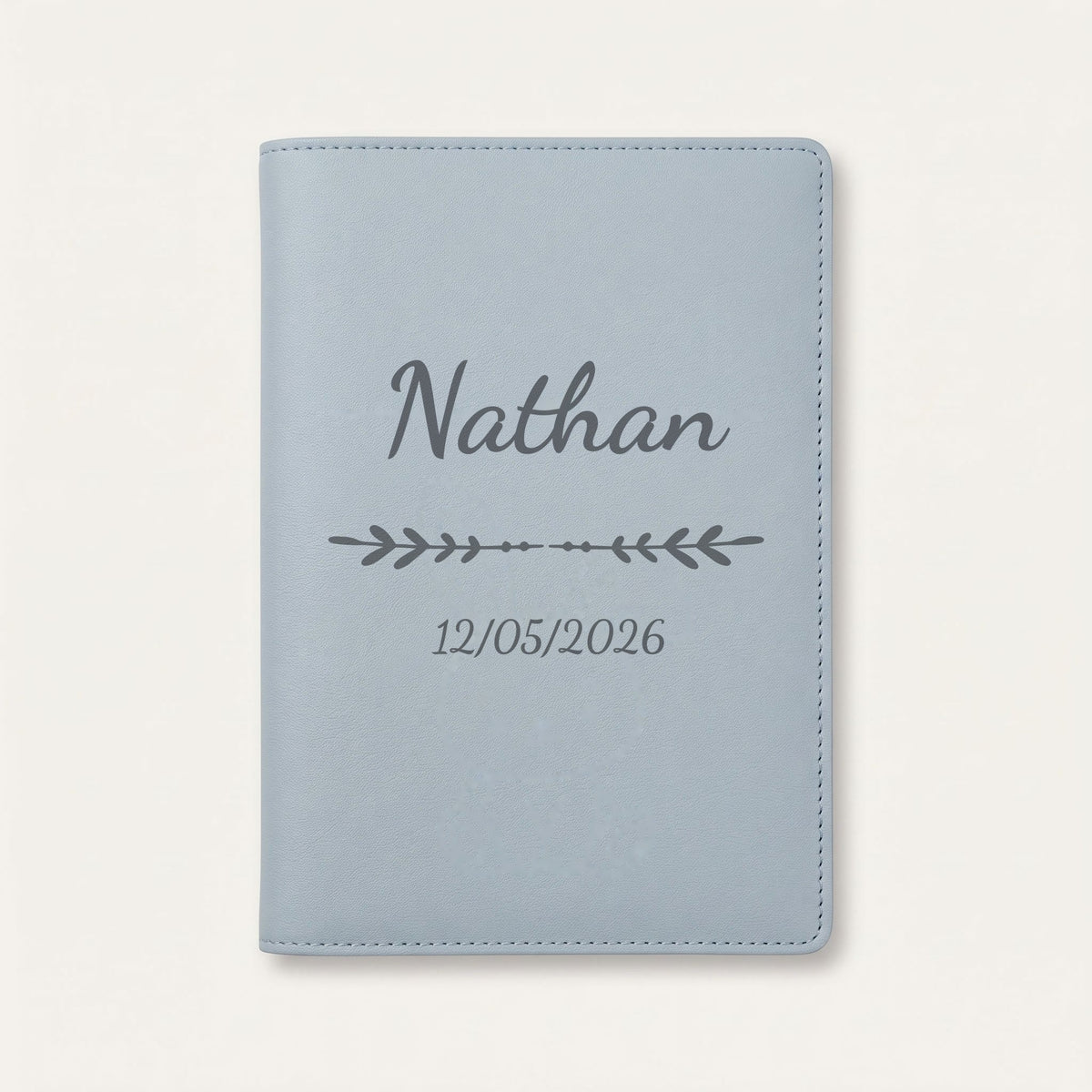 Protège carnet de santé personnalisé Nathan — Bleu nuage — prénom « Nathan », ornement Flèche et date de naissance « 12/05/2026 » gravés