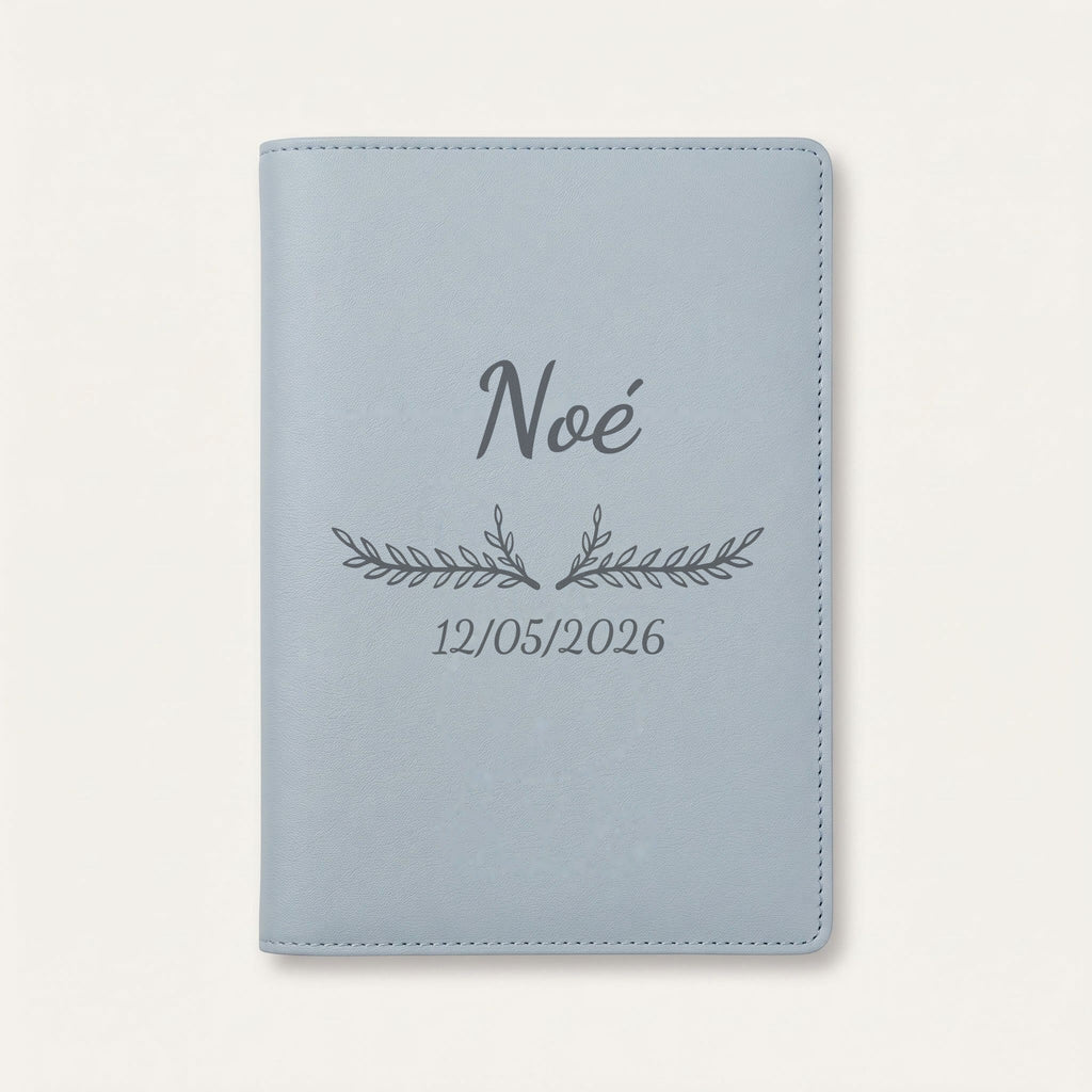 Protège carnet de santé personnalisé Noé — Bleu nuage — prénom « Noé », ornement Bouquet et date de naissance « 12/05/2026 » gravés