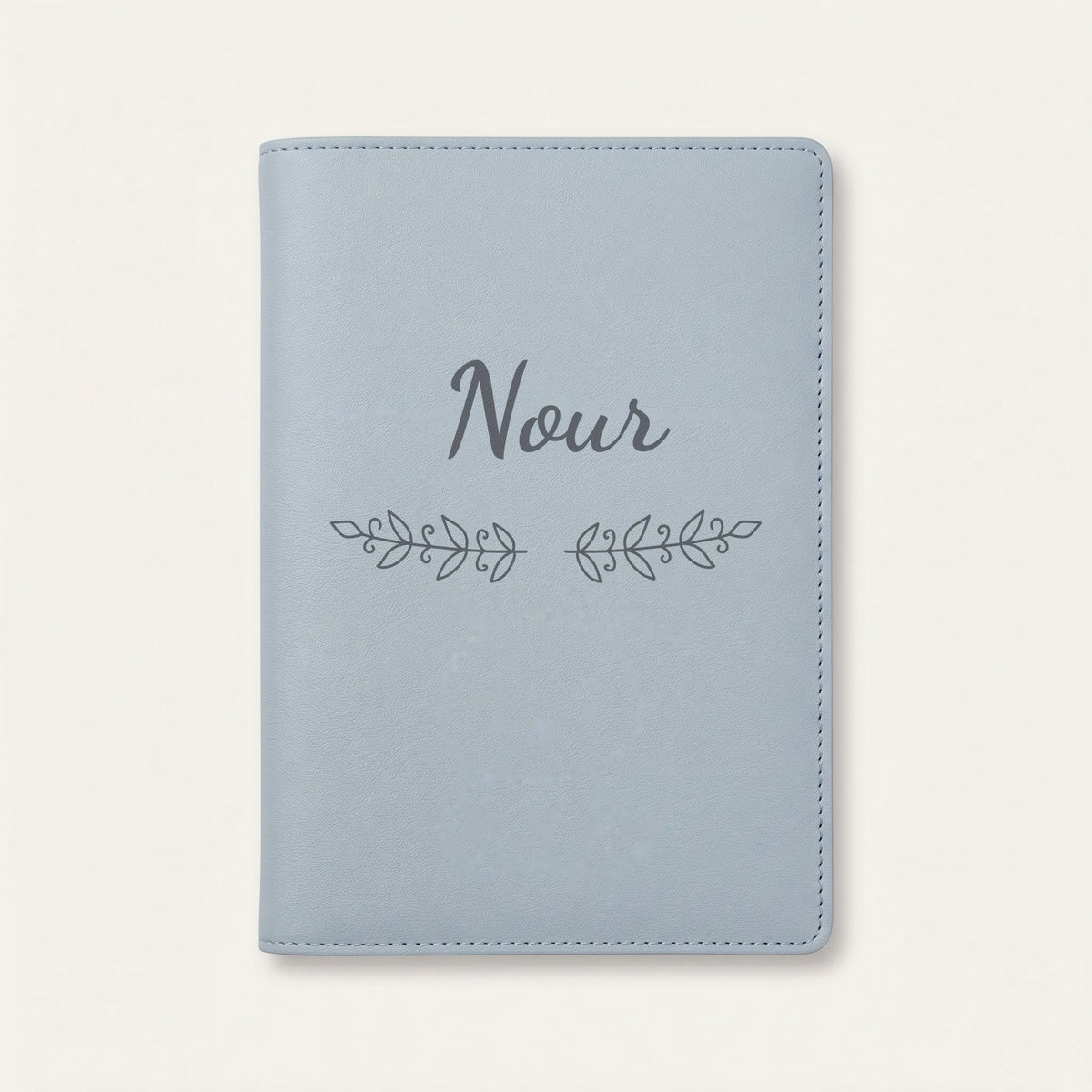 Protège carnet de santé personnalisé Nour — Bleu nuage — prénom « Nour » gravé, ornement Volutes