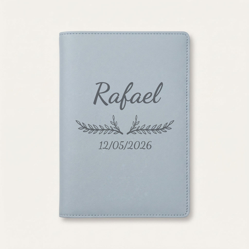 Protège carnet de santé personnalisé Rafael — Bleu nuage — prénom « Rafael », ornement Bouquet et date de naissance « 12/05/2026 » gravés