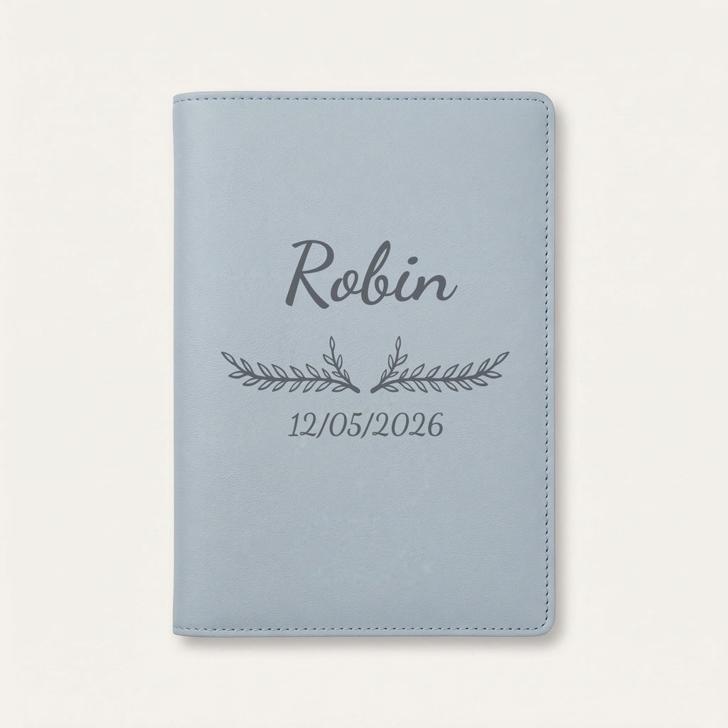 Protège carnet de santé personnalisé Robin — Bleu nuage — prénom « Robin », ornement Bouquet et date de naissance « 12/05/2026 » gravés